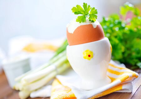 boiled eggs and fresg greens on a tableの写真素材