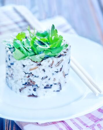 boiled rice on plate and on a tableの写真素材