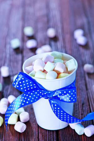 marshmallow in paper cup and on a tableの写真素材