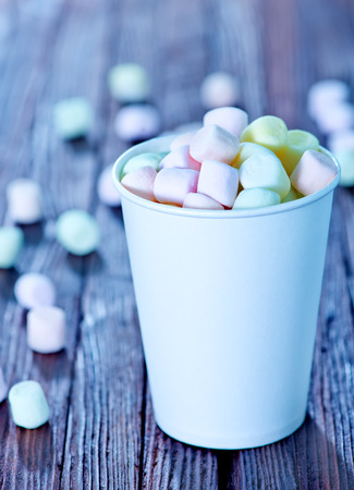 marshmallow in paper cup and on a tableの写真素材