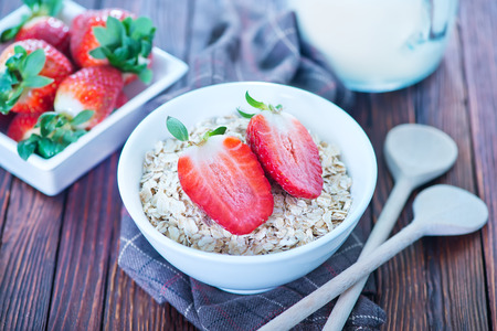 raw oat flakes in the white bowlの写真素材
