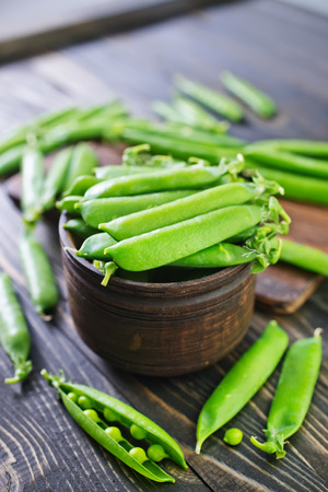 green peas in bowl and on a tableの写真素材