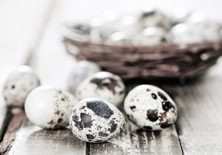quail eggs on the nest and on the wooden tableの写真素材