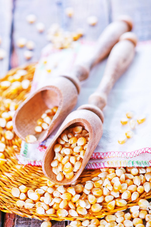dry corn in wooden spoon and on a tableの写真素材