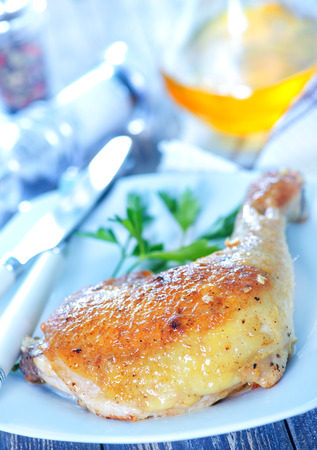 fried chicken leg on plate and on a tableの写真素材