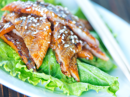 salad with fried eel and sauce on the plateの写真素材