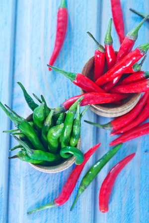 green and red chilli peppers on a tableの写真素材
