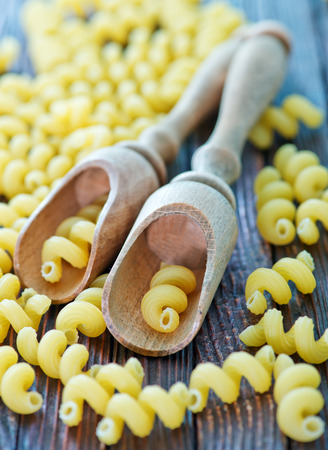 raw pasta in spoon and on the wooden boardの写真素材