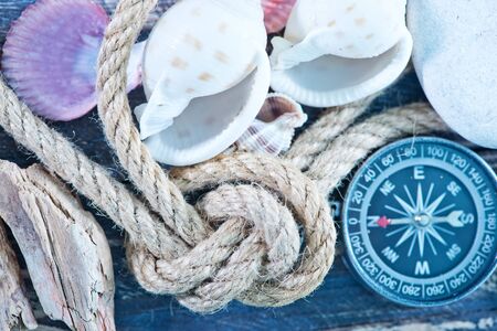 background, sea shells and compass on a tableの写真素材