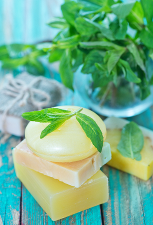 soap and mint leaves on the wooden tableの写真素材