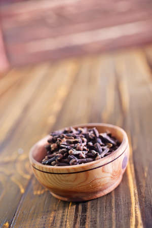 cloves in wooden bowl and on a tableの写真素材