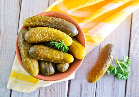 pickled cucumbers in bowl and on a tableの写真素材
