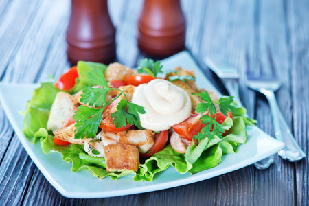 caesar salad on white plate and on a tableの写真素材
