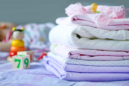 baby clothes on the bed, color baby linenの写真素材