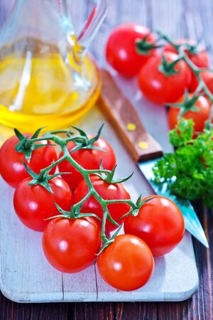 tomato cherry and knife on tha wooden tableの写真素材