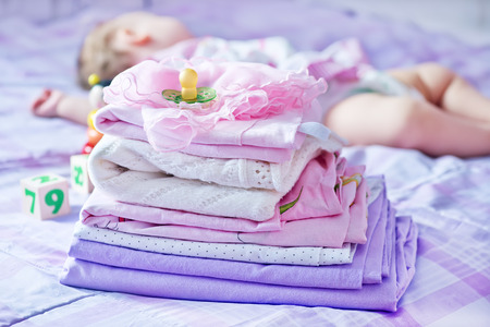 baby clothes on the bed, color baby linenの写真素材