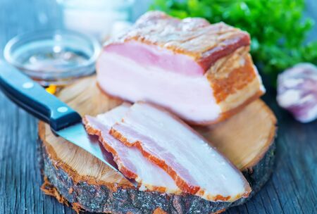 smoked lard on wooden board and on a tableの写真素材