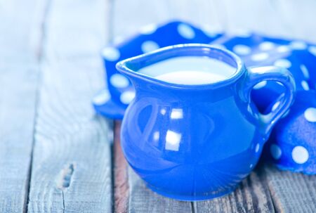 fresh milk in jug and on a tableの写真素材