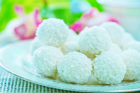 coconut balls on the white plate and on a tableの写真素材