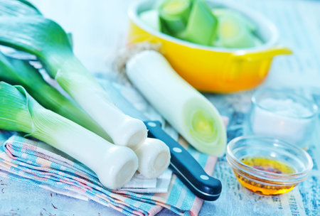 fresh leek and knife on the wooden table
