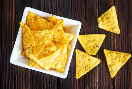 nachos in the white bowl and on a table