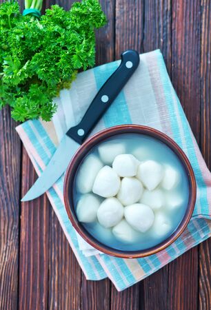 fresh mozzarella in bowl and on a tableの写真素材