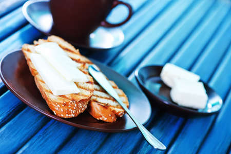 bread with butter on plate and on a tableの写真素材