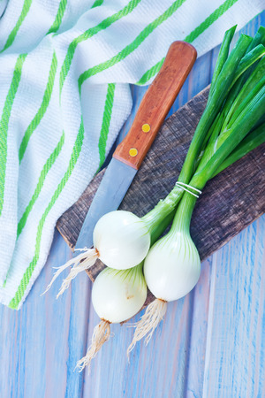 fresh onion and knife on the wooden tableの写真素材