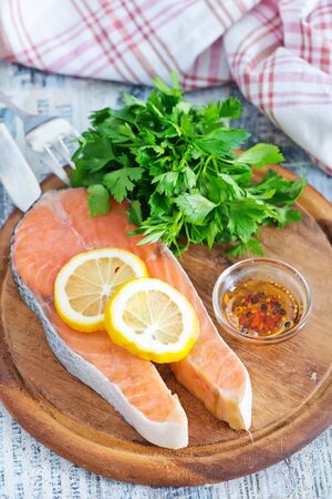 fresh salmon and lemon on the wooden boardの写真素材