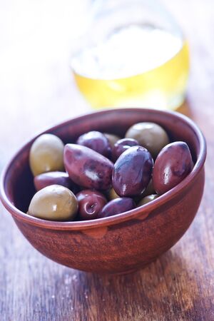 olives and olive oil on a tableの写真素材