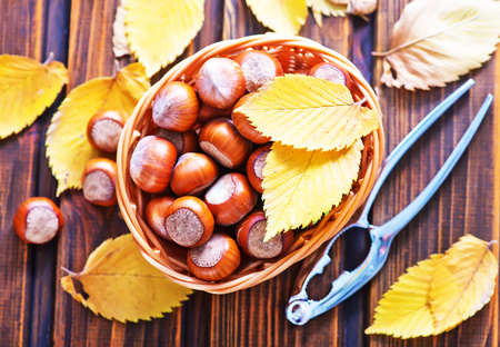 autumn leaves and hazelnuts on a tableの写真素材