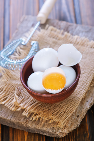 raw eggs in bowl and on a tableの写真素材