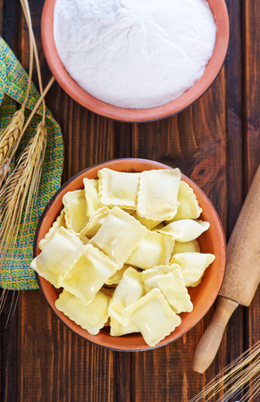 raw ravioli and flour on a tableの写真素材