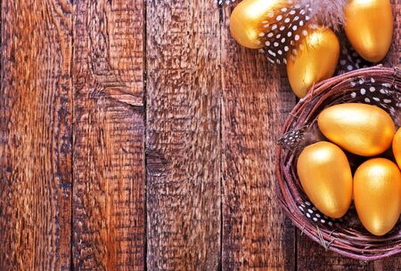 golden eggs in nest and on a tableの写真素材