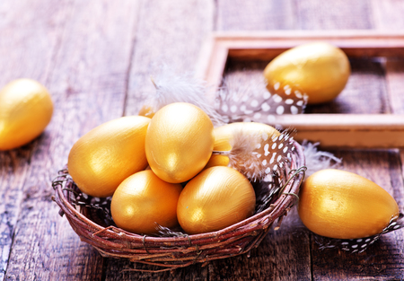 golden eggs in nest and on a tableの写真素材