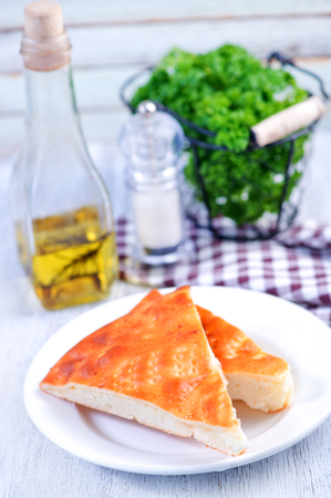 pie with cheese on plate and on a tableの写真素材