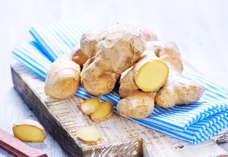 fresh ginger on board and on a tableの写真素材