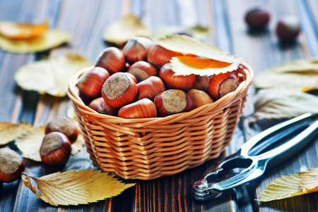 autumn leaves and hazelnuts on a tableの写真素材