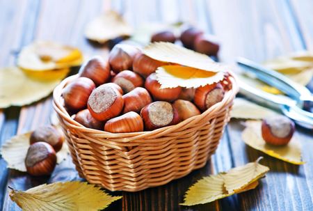 autumn leaves and hazelnuts on a tableの写真素材