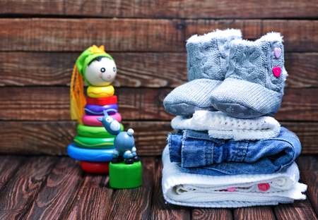 baby clothes and shoes on the wooden tableの写真素材