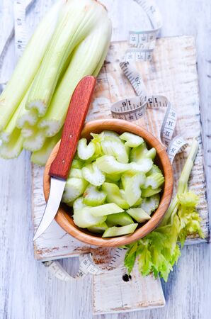 celery in bamboo bowl and on a tableの写真素材
