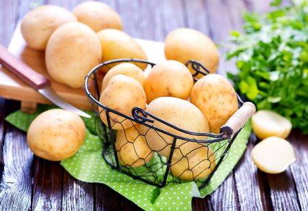 raw potato and knife on the wooden tableの写真素材