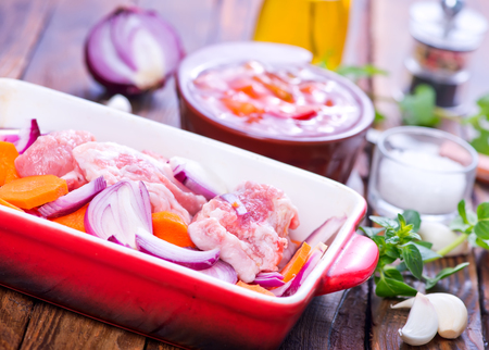 raw meat with vegetables in the bowl and on a tableの写真素材
