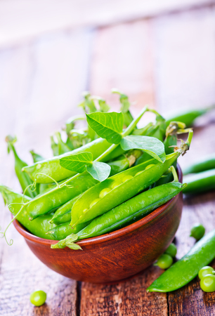 green peas in bowl and on a tableの写真素材