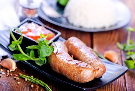 boiled rice with fried sausages on the plateの写真素材