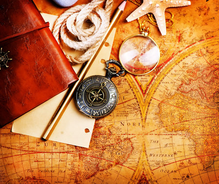 old notebook, loupe and compass on the map