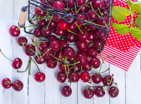 fresh cherry in metal basket and on a tableの写真素材