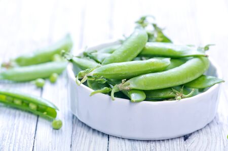green peas in bowl and on a tableの写真素材