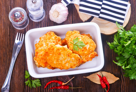 chicken cutlets in bowl and on a tableの写真素材
