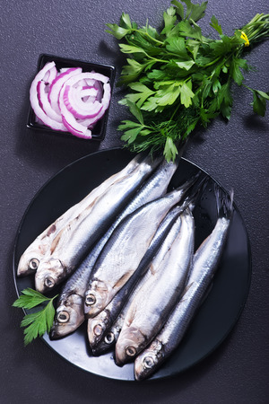 fish with salt and spice on the black plateの写真素材